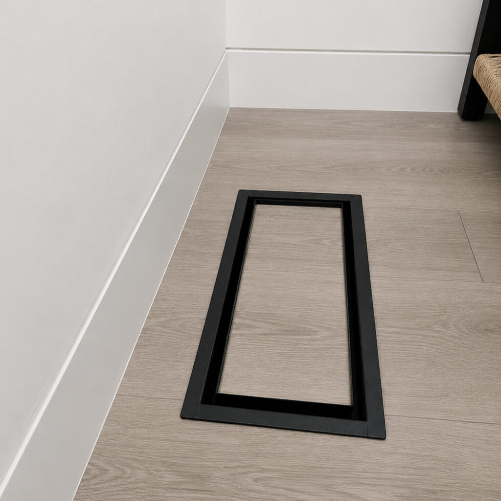 Black floor-matching vent cover installed in wood flooring